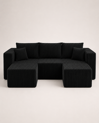 A modern black corduroy sectional sofa with two matching square ottomans, photographed against a clean, light off-white studio background.