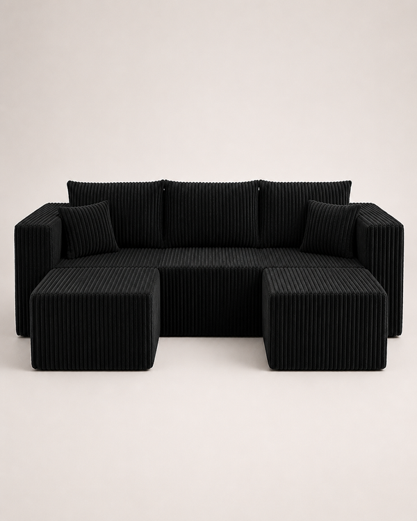 A modern black corduroy sectional sofa with two matching square ottomans, photographed against a clean, light off-white studio background.
