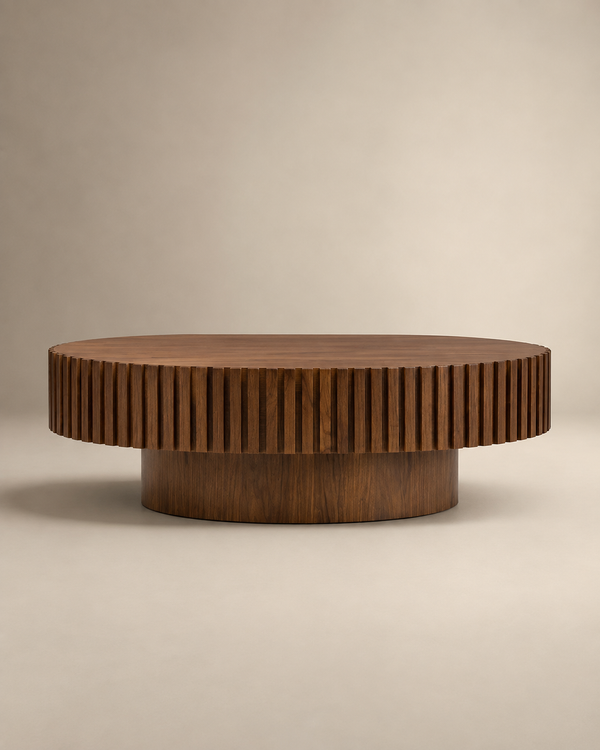 A round wooden coffee table with a fluted, ribbed outer edge and a cylindrical base, shown on a neutral beige studio background.
