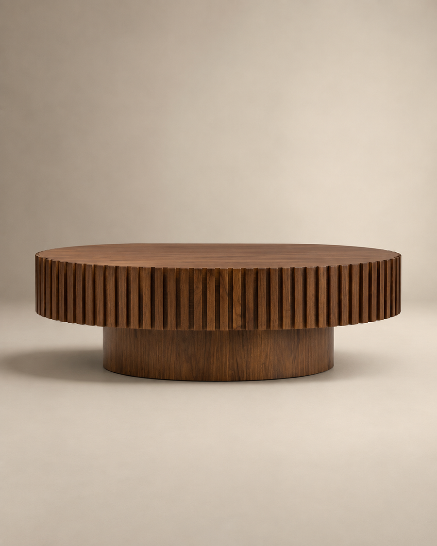 A round wooden coffee table with a fluted, ribbed outer edge and a cylindrical base, shown on a neutral beige studio background.