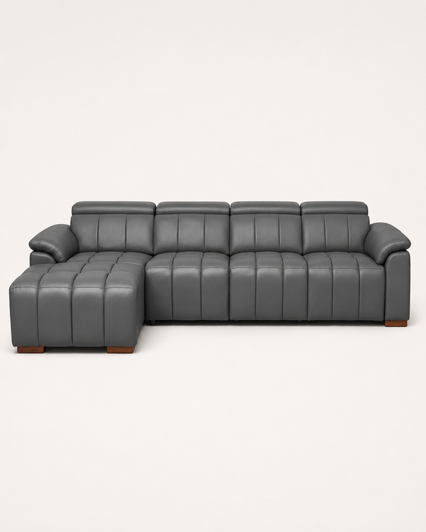 A modern gray leather sectional sofa with a left-facing chaise ottoman and vertical channel tufting, shown against a plain off-white background.