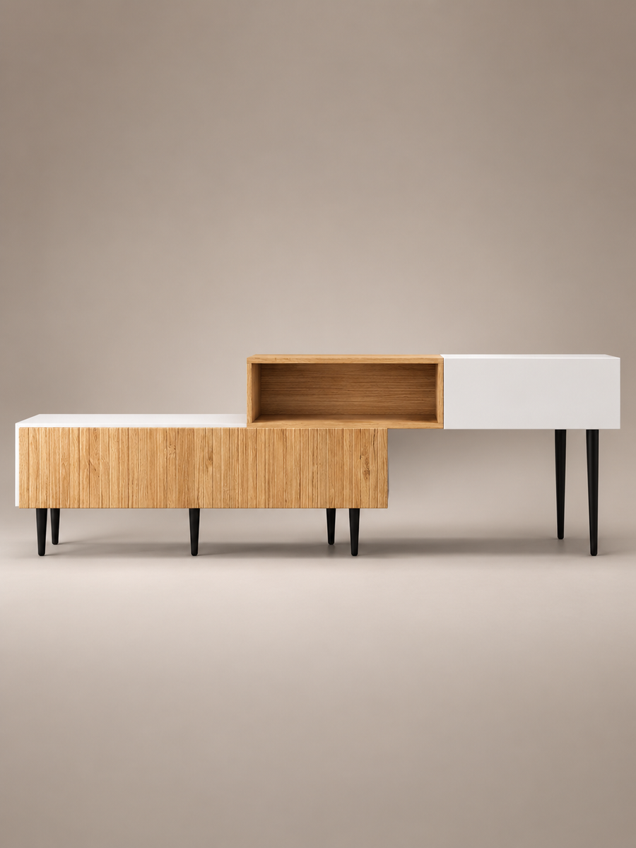 A modern low-profile sideboard or console table with a geometric design, featuring a light wood grain front, a white panel, an open cubby, and a closed compartment, supported by slim black legs, set against a solid neutral beige background.