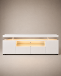 A modern white media console with a lift-top design, illuminated by warm yellow LED lighting inside. The cabinet features two side cabinets, two central drawers, and a glass shelf in the center, supported by clear acrylic pillars under the top surface.
