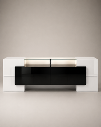 A modern low-profile media console with a glossy black front and white side cabinets, set against a neutral beige background.