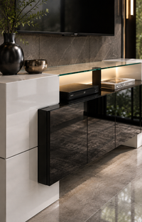Modern floating media console in black and glass, styled in a contemporary living room with a white side cabinet, a glass TV stand, and a wall-mounted screen.