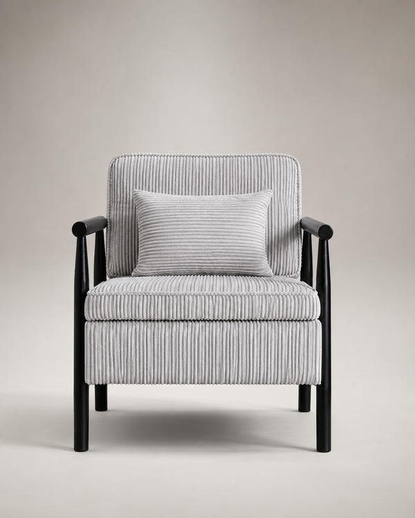 A modern armchair with a black wooden frame and a light gray and white vertically striped ribbed fabric upholstery, featuring a matching square throw pillow, set against a neutral beige studio background.