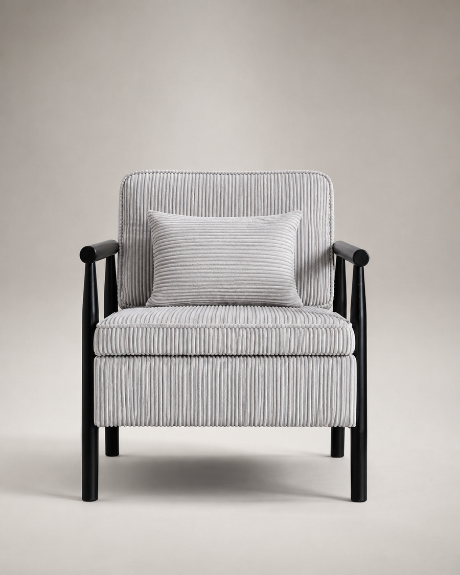 A modern armchair with a black wooden frame and a light gray and white vertically striped ribbed fabric upholstery, featuring a matching square throw pillow, set against a neutral beige studio background.