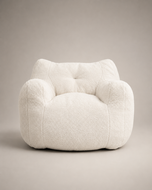 A plush, rounded armchair upholstered in a textured bouclé fabric, shown from the front against a neutral warm gray studio background.
