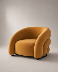 A modern curved armchair upholstered in mustard yellow velvet, shown on a neutral gray studio background.