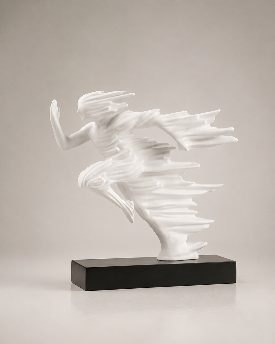 A white abstract figurative sculpture of a dancing or flying human form mounted on a rectangular black base, photographed against a plain light gray studio background.