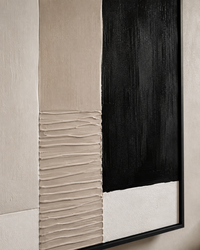 Abstract framed wall art featuring a bold vertical composition with a large black rectangular section, a textured beige ribbed panel, and a white section, all within a thin black frame against a neutral beige wall.
