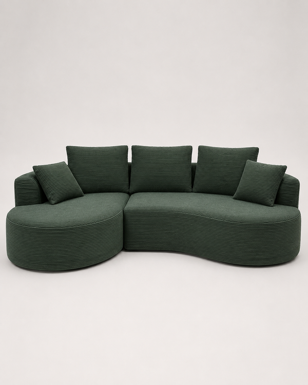 A curved modular upholstered sofa in dark green corduroy fabric with matching square throw pillows, photographed against a plain light gray studio background.