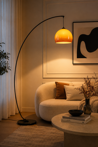 Solenne Arc Glass Floor Lamp extending over a sofa in a modern luxury living room