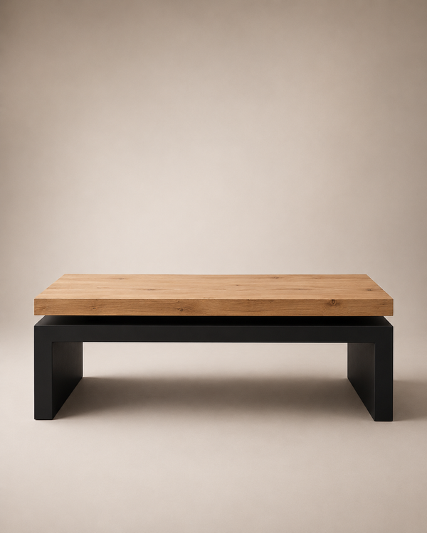 A modern low coffee table with a light natural wood top and a matte black metal base, photographed against a neutral beige studio background.