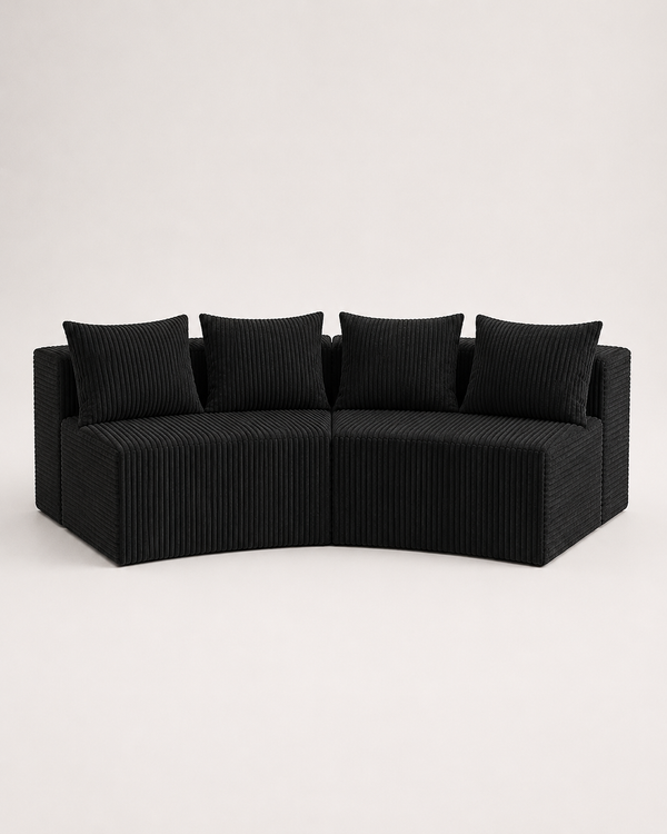 A curved outdoor sectional sofa upholstered in black corduroy fabric with four matching square back cushions, shown against a plain light gray studio background.