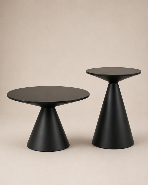 Two modern black side tables with circular tops and tapered cone bases, photographed on a plain warm beige studio background.