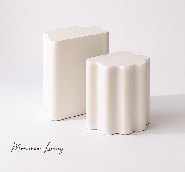 Two modern ceramic side tables with wavy scalloped edges, one rectangular and one cylindrical, in a warm off-white/cream color, set against a clean white background.