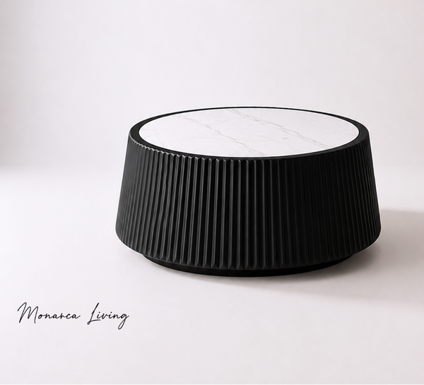 A modern black ribbed cylindrical side table with a white marble top, photographed on a clean white studio background with a 'Monaco Living' watermark in the lower left.
